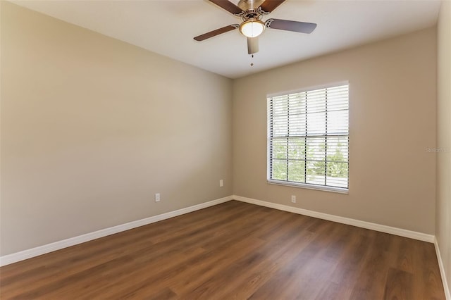 unfurnished room with dark wood-style floors, baseboards, and a ceiling fan