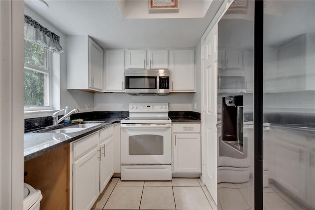 kitchen with sink, light tile patterned flooring, electric stove, and white cabinets