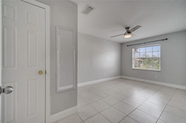 tiled spare room with ceiling fan