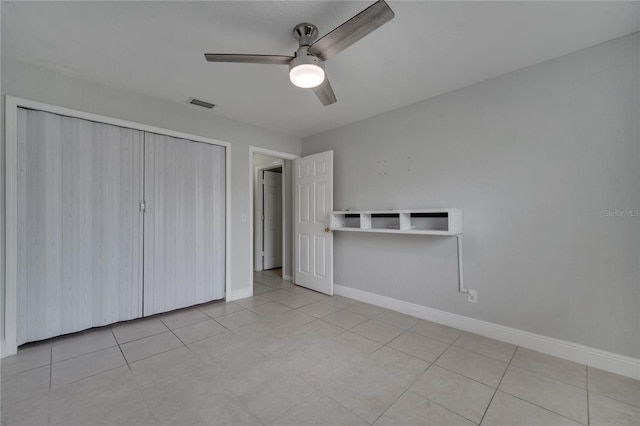 unfurnished bedroom featuring ceiling fan, a closet, and light tile patterned floors