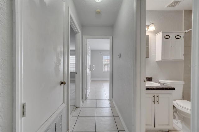 bathroom featuring toilet, tile patterned flooring, a textured ceiling, and vanity