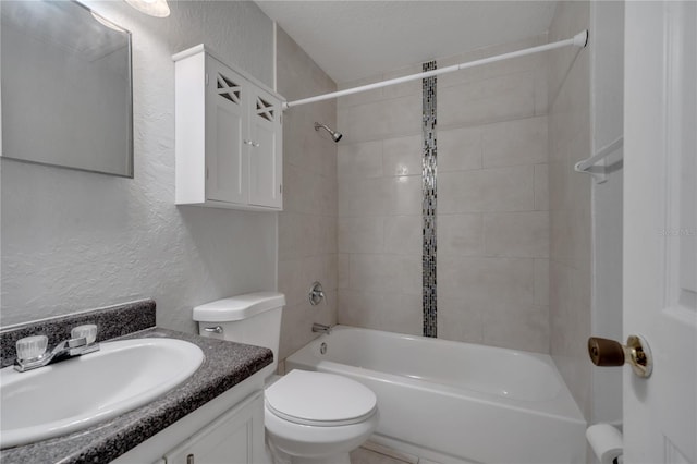 full bathroom with toilet, tiled shower / bath, and vanity