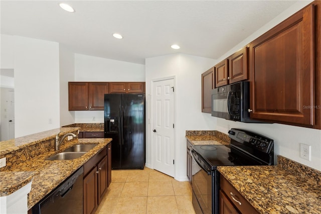 kitchen featuring dark stone counters, sink, light tile patterned floors, and black appliances