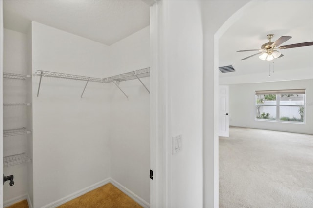 walk in closet with carpet flooring and ceiling fan