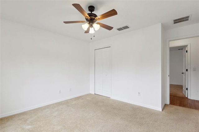 empty room with ceiling fan and light colored carpet