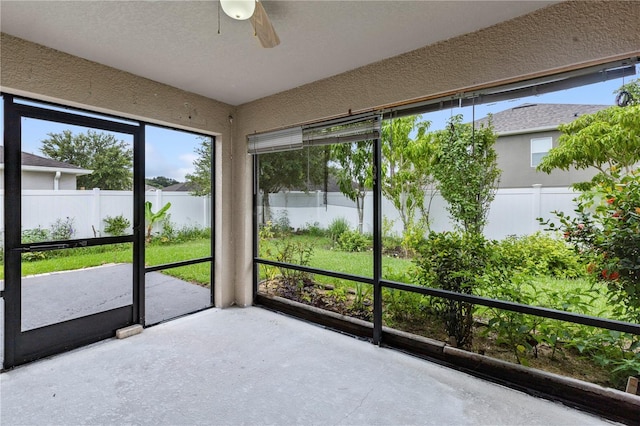 unfurnished sunroom with ceiling fan