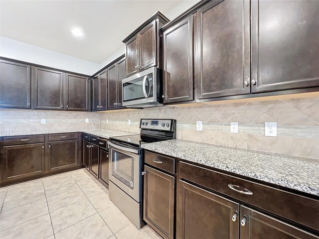 kitchen featuring light tile patterned floors, stainless steel appliances, decorative backsplash, and light stone countertops