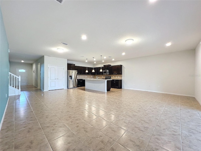 unfurnished living room featuring baseboards, stairs, light tile patterned flooring, a sink, and recessed lighting