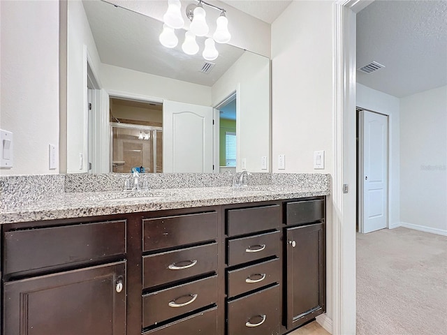 bathroom featuring visible vents, a sink, and a shower stall