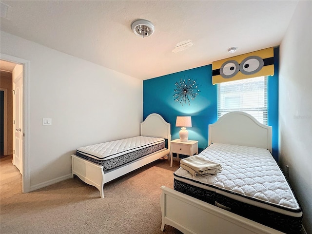 bedroom featuring light carpet and baseboards