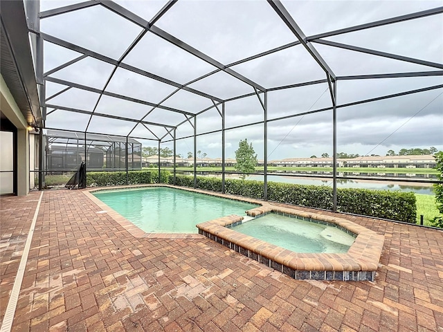 view of swimming pool with a patio area, a water view, a lanai, and a pool with connected hot tub