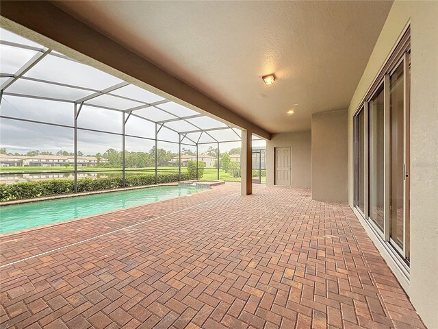 view of swimming pool featuring a lanai, a pool with connected hot tub, and a patio