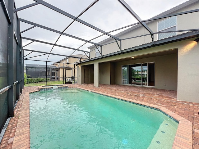 view of swimming pool with glass enclosure, a patio area, and a pool with connected hot tub