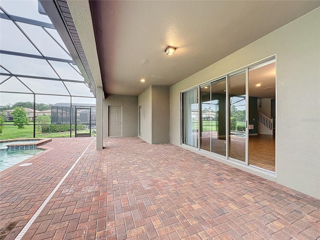 view of patio / terrace with a lanai and a pool with connected hot tub