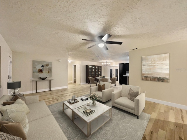 living room with ceiling fan, light hardwood / wood-style floors, and a textured ceiling