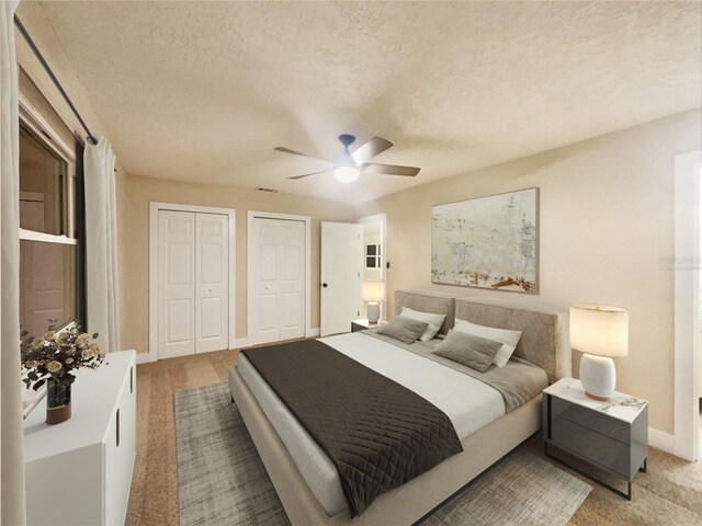 bedroom with ceiling fan, multiple closets, a textured ceiling, and light carpet