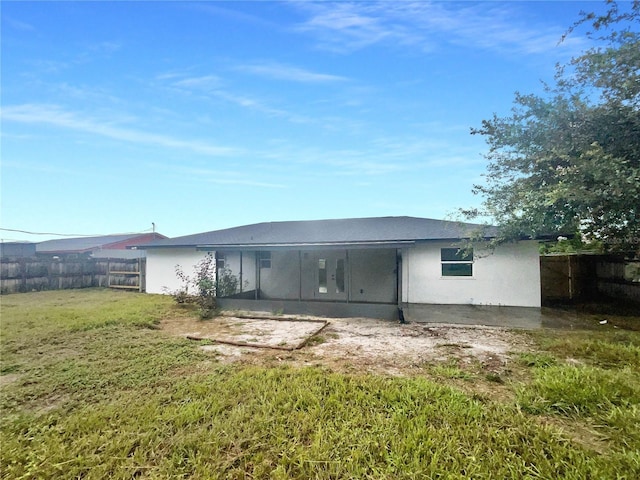 rear view of property featuring a patio and a lawn