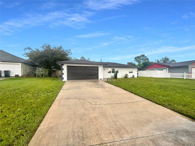 single story home featuring a front lawn and a garage