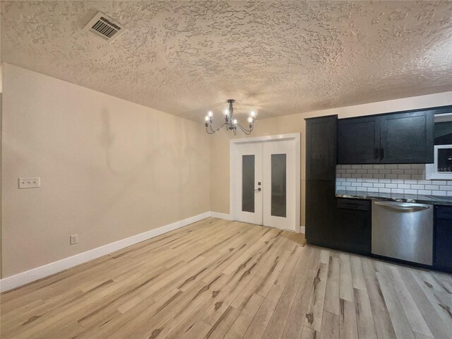 kitchen featuring a textured ceiling, light hardwood / wood-style flooring, stainless steel dishwasher, and an inviting chandelier