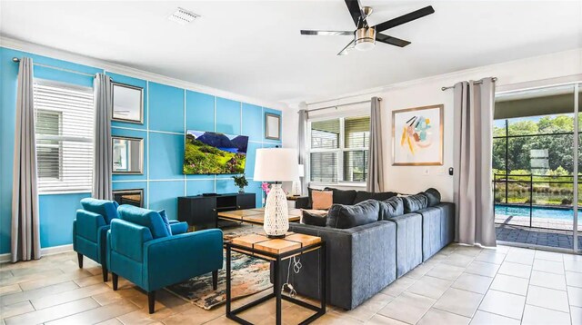 tiled living room with ceiling fan and ornamental molding