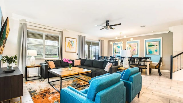 tiled living room featuring ceiling fan with notable chandelier and ornamental molding