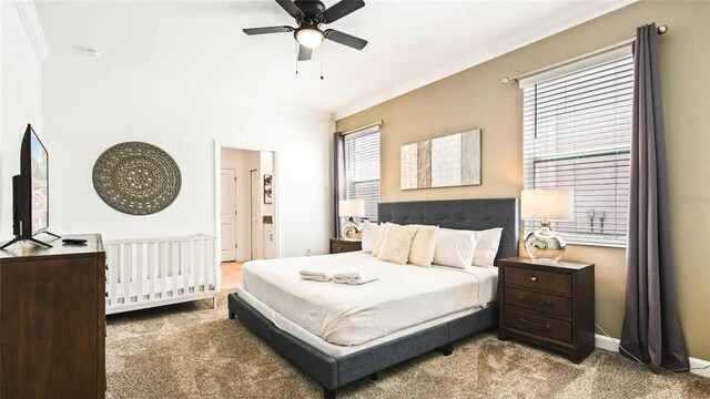 carpeted bedroom with ceiling fan and crown molding