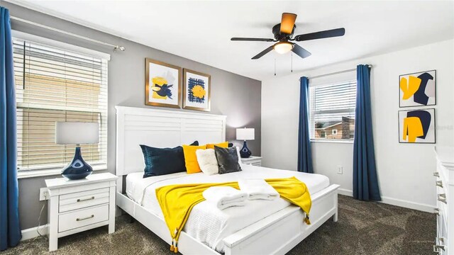 bedroom featuring ceiling fan and dark carpet