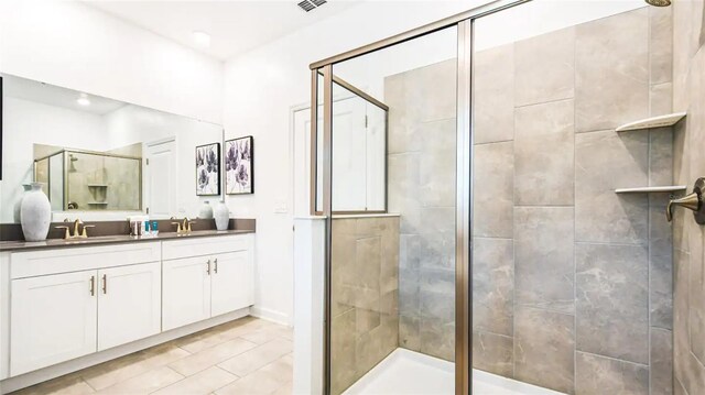 bathroom featuring a shower with door, tile patterned floors, and vanity