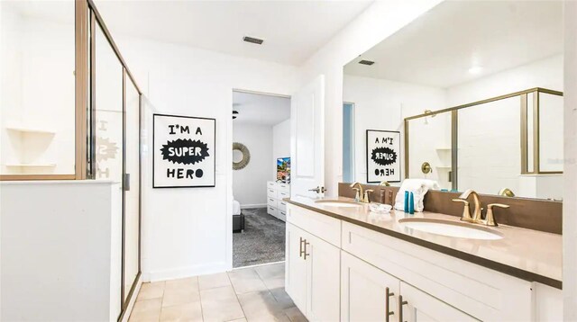 bathroom with tile patterned flooring, vanity, and a shower with shower door