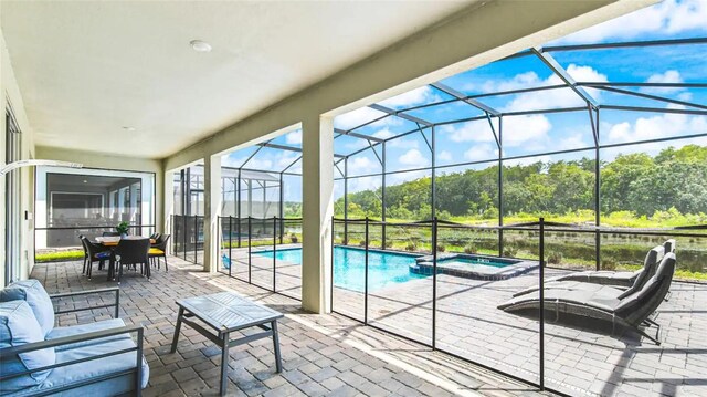 view of pool with an in ground hot tub, a patio area, and a lanai