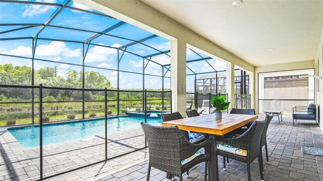 view of pool with glass enclosure, a patio, and an in ground hot tub