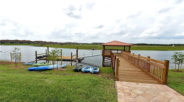 dock area with a water view, a lawn, and a gazebo