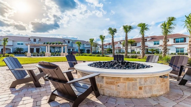 view of community featuring a fire pit, a patio area, and a yard