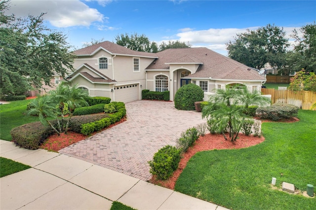 mediterranean / spanish house with a garage and a front lawn