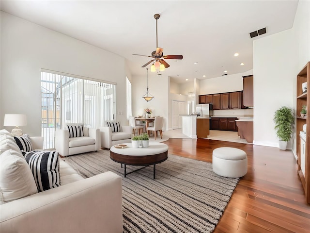 living room with ceiling fan and light wood-type flooring