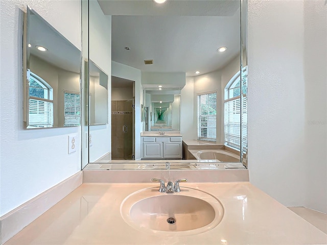 bathroom featuring vanity and separate shower and tub