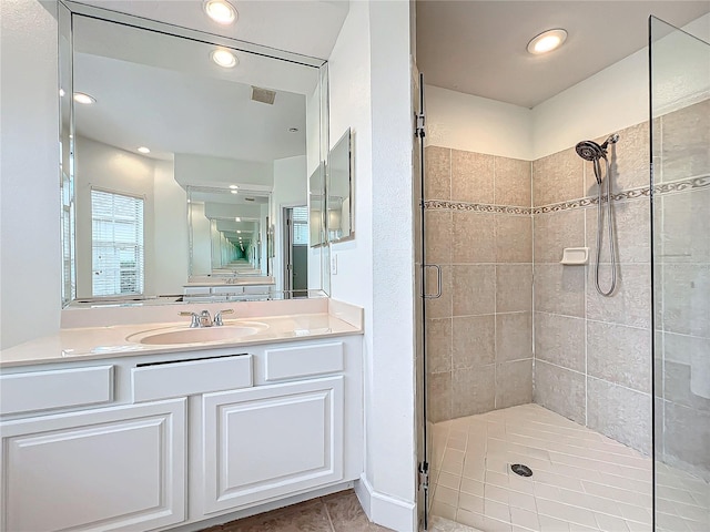 bathroom featuring an enclosed shower, vanity, and tile patterned flooring