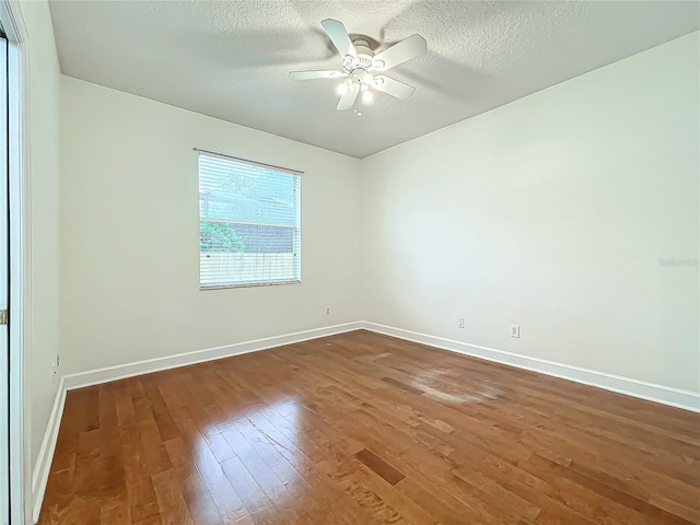 spare room with dark hardwood / wood-style flooring, a textured ceiling, and ceiling fan