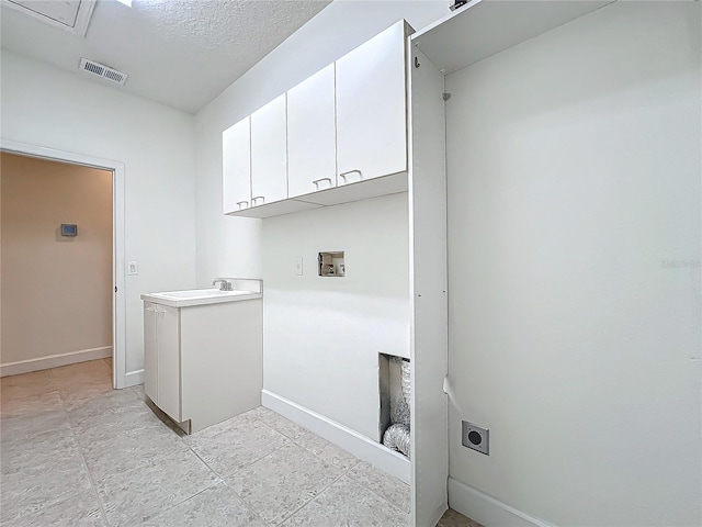 clothes washing area with cabinets, sink, hookup for a washing machine, and electric dryer hookup