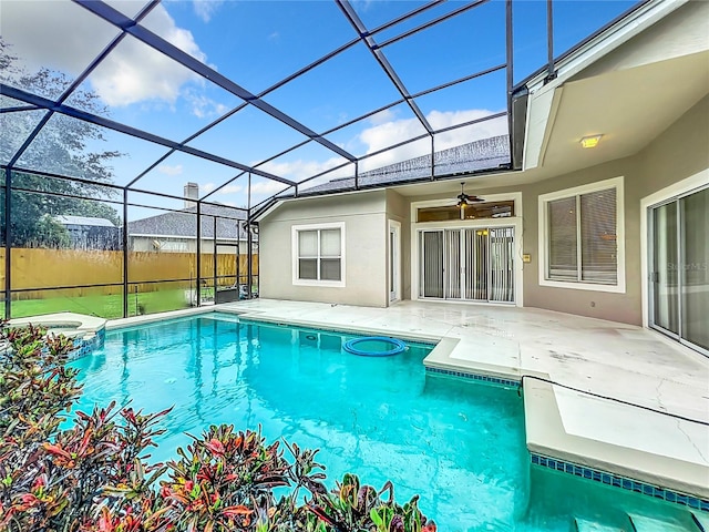 view of swimming pool featuring ceiling fan, a patio, and glass enclosure