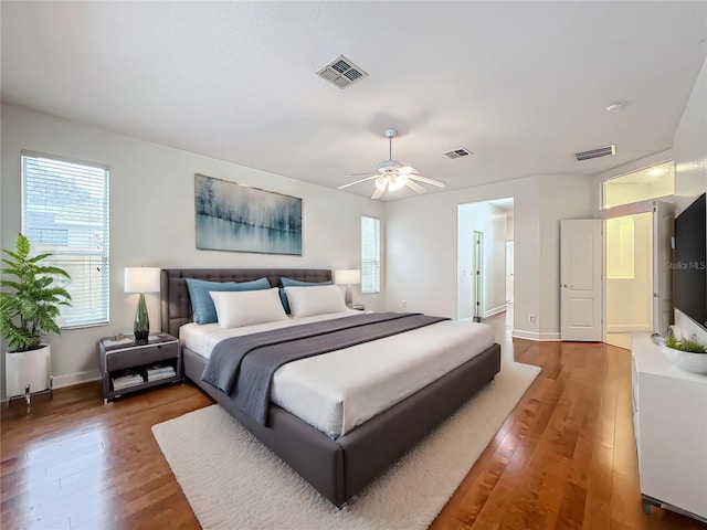 bedroom featuring multiple windows, dark hardwood / wood-style flooring, and ceiling fan