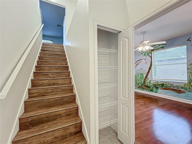 stairway featuring hardwood / wood-style floors and ceiling fan