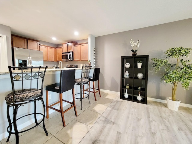 kitchen featuring kitchen peninsula, a breakfast bar, and stainless steel appliances