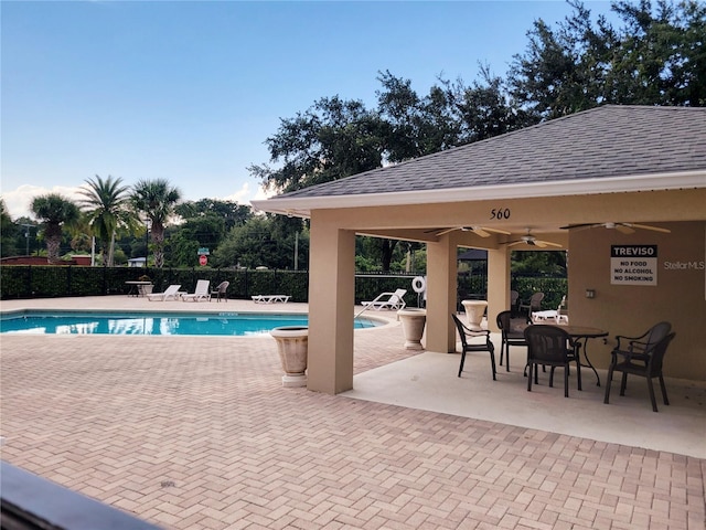 view of swimming pool featuring ceiling fan and a patio area