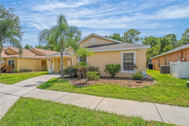 ranch-style home with cooling unit and a front yard