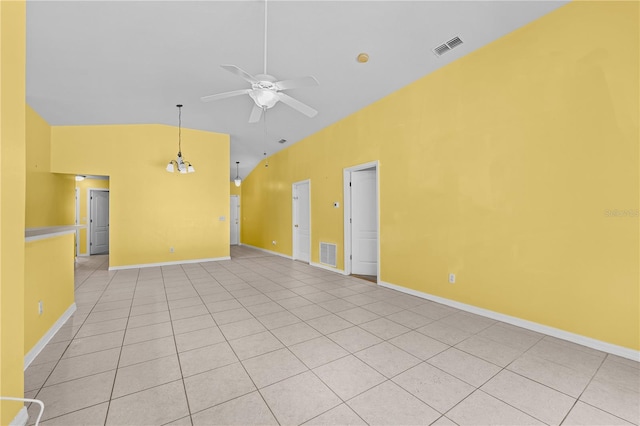 tiled empty room with ceiling fan and high vaulted ceiling