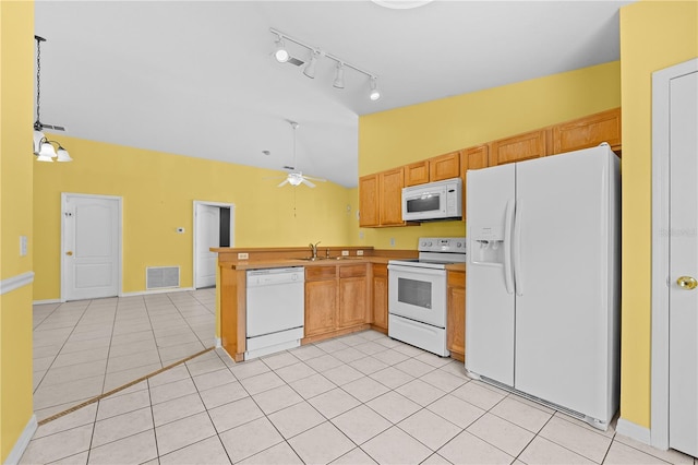 kitchen featuring white appliances, vaulted ceiling, rail lighting, and light tile patterned floors