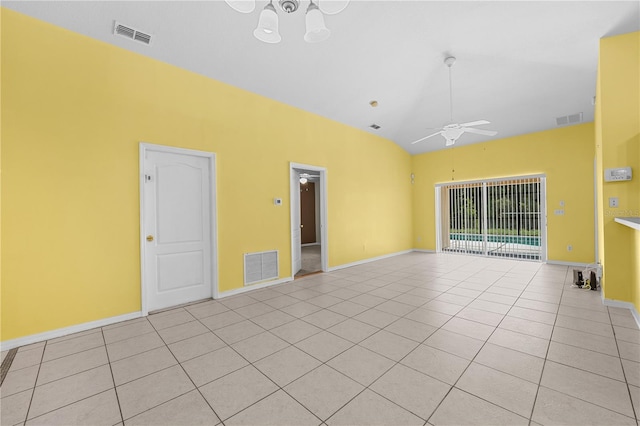 tiled empty room with ceiling fan with notable chandelier and vaulted ceiling