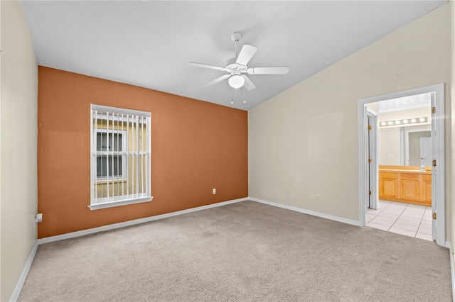 empty room featuring ceiling fan, light carpet, and vaulted ceiling