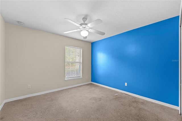 carpeted spare room with a textured ceiling and ceiling fan